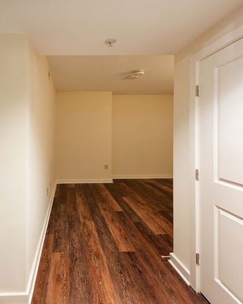 an empty room with wood floors and white walls